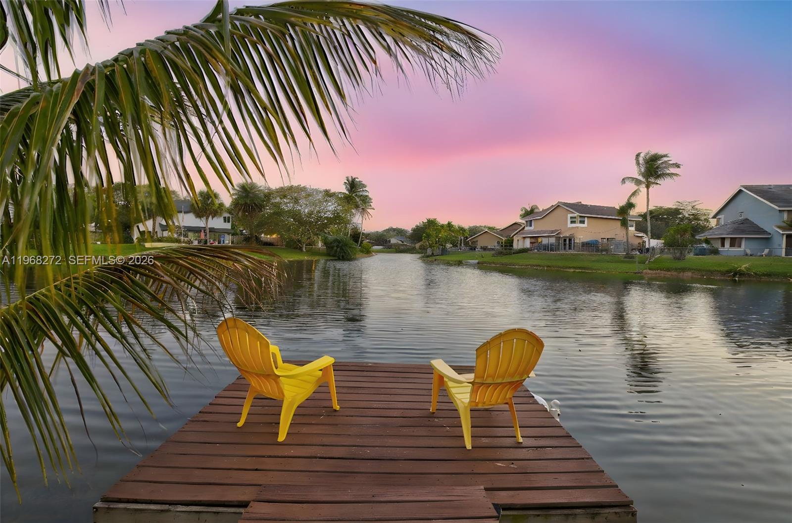 8740 Southwest 56th Place Cooper City, FL 33328 - Photo 2 of 54 a view of a lake with couches chairs and wooden floor