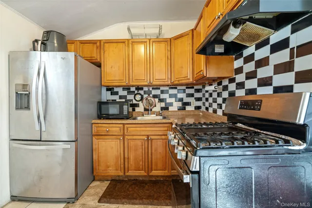 a kitchen with stainless steel appliances granite countertop a stove a refrigerator and a stove