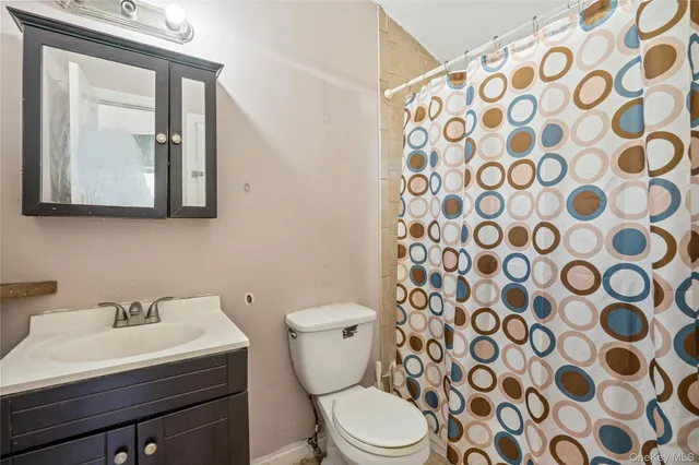 a bathroom with a toilet a sink and a mirror