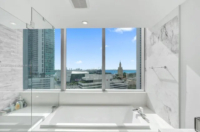 a bathroom with a large tub sink vanity and windows