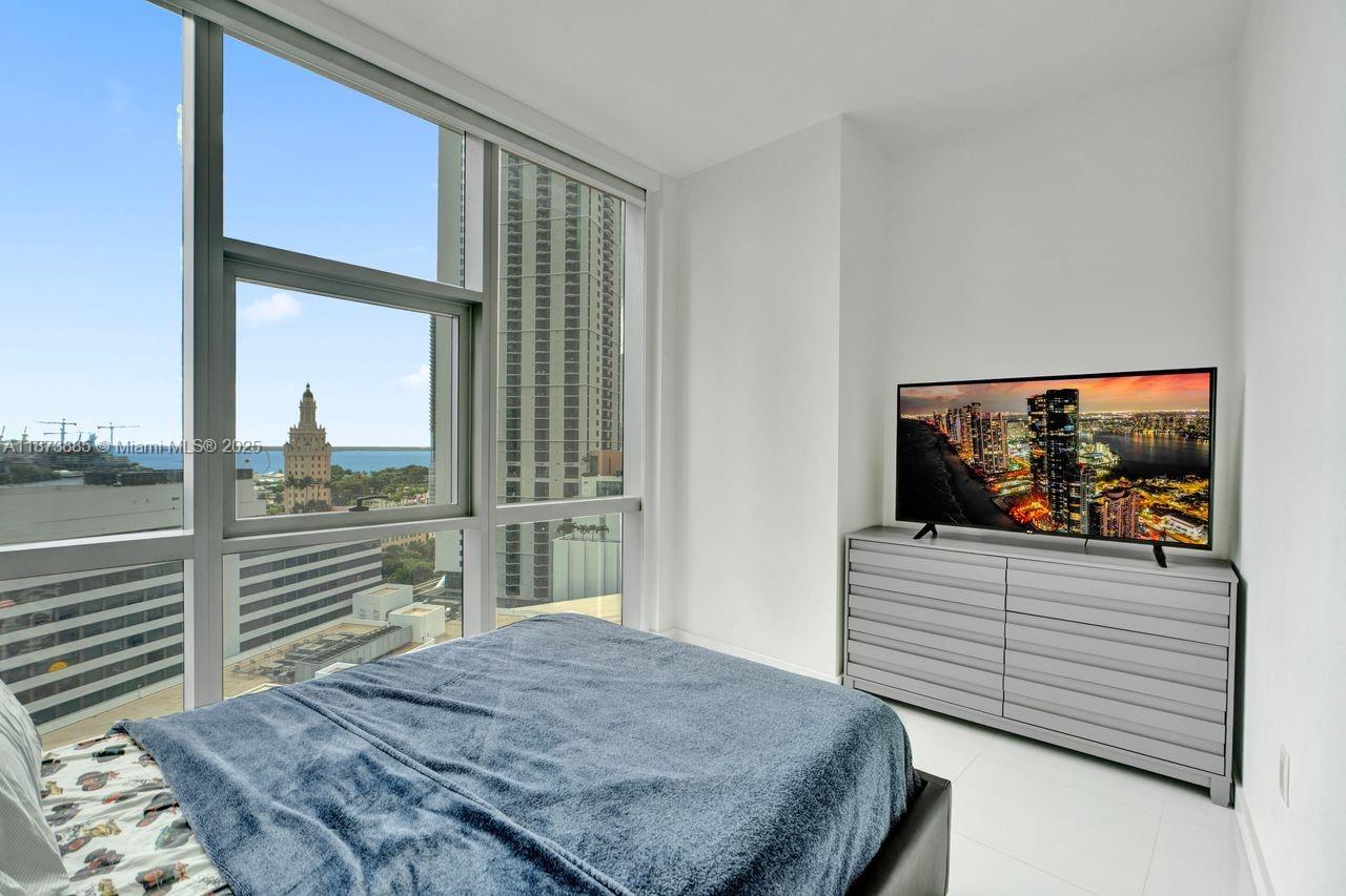 851 Northeast 1st Avenue, Unit 1411 Miami, FL 33132 - Photo 24 of 58 a bedroom with a bed and a flat tv screen on dresser
