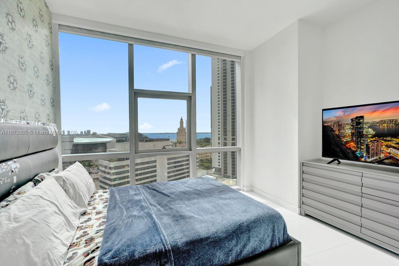 851 Northeast 1st Avenue, Unit 1411 Miami, FL 33132 - Photo 25 of 58 a bedroom with a bed and a flat tv screen on dresser
