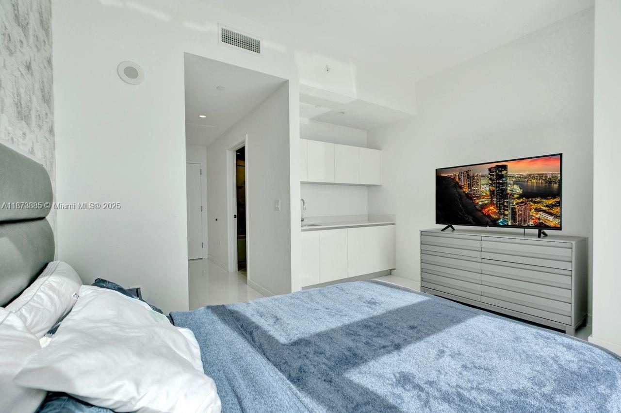 851 Northeast 1st Avenue, Unit 1411 Miami, FL 33132 - Photo 29 of 58 a bedroom with a bed and a flat screen tv