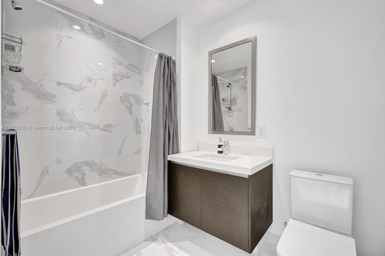 851 Northeast 1st Avenue, Unit 1411 Miami, FL 33132 - Photo 30 of 58 a bathroom with a sink a toilet and shower