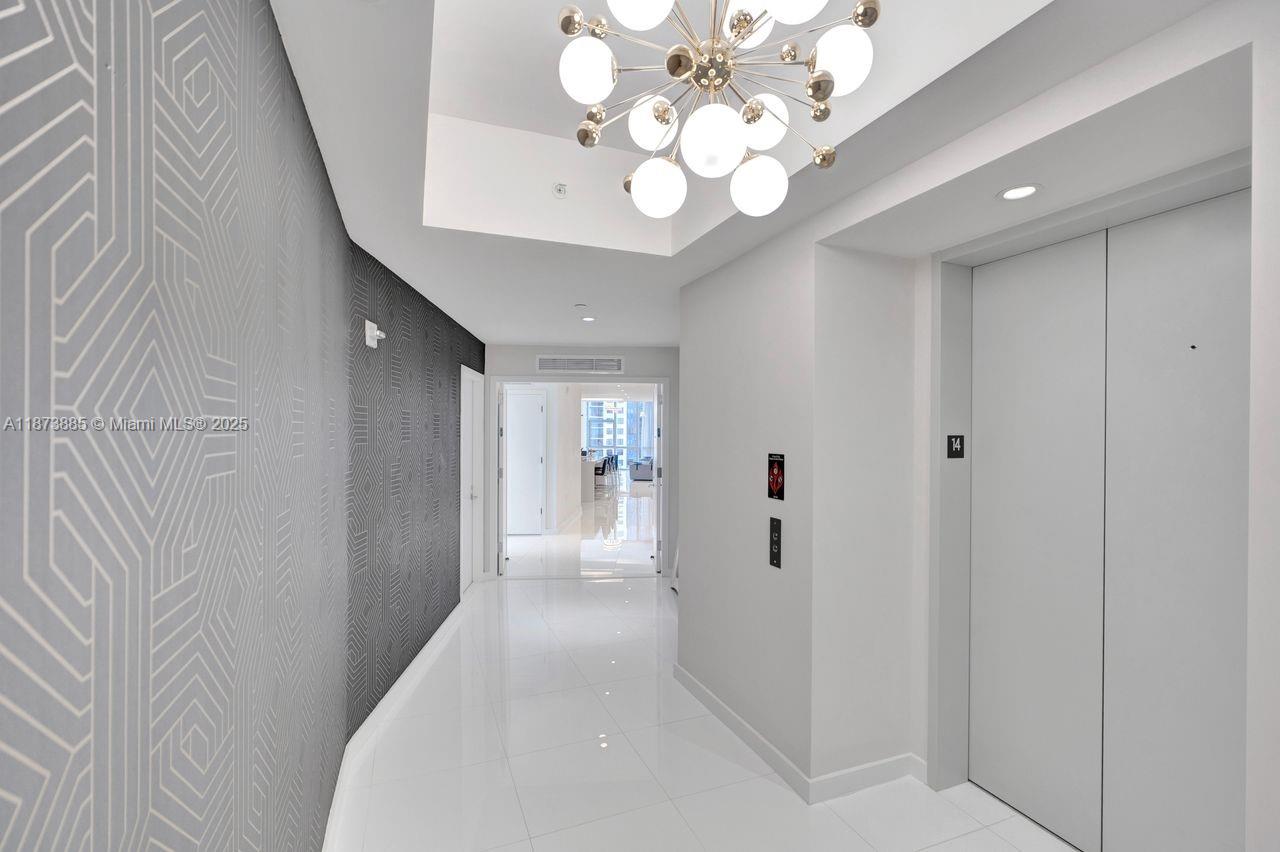 851 Northeast 1st Avenue, Unit 1411 Miami, FL 33132 - Photo 35 of 58 a view of a hallway with wooden floor and chandelier