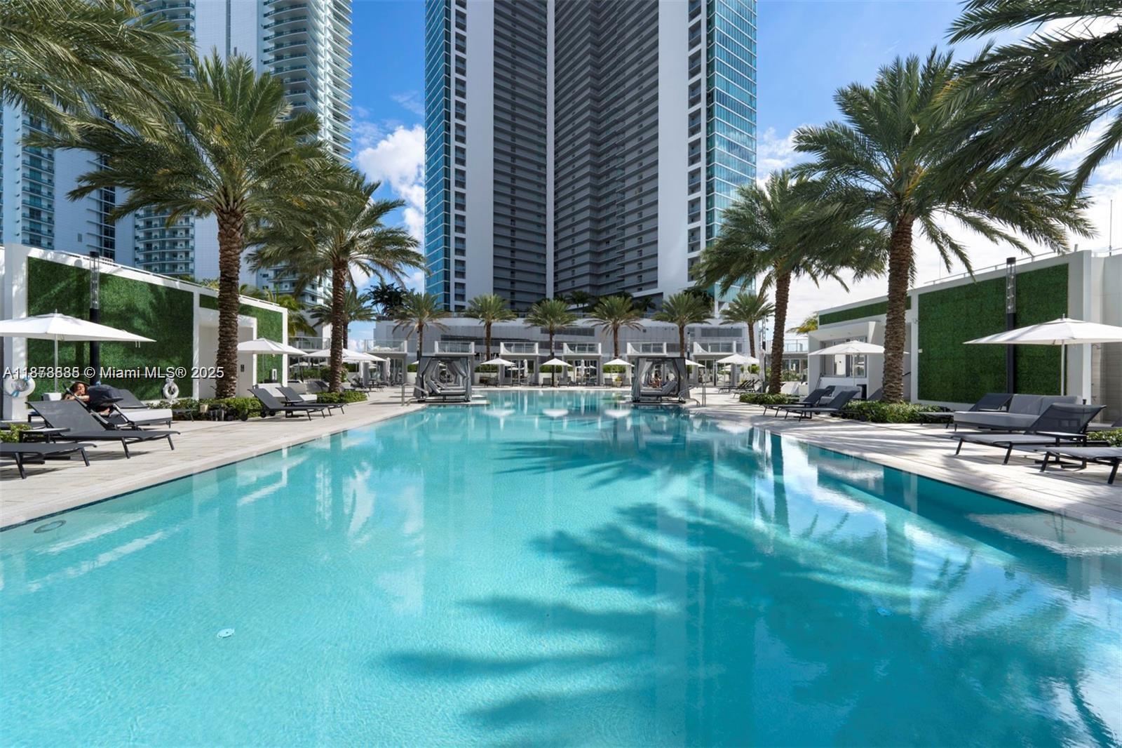 851 Northeast 1st Avenue, Unit 1411 Miami, FL 33132 - Photo 43 of 58 a swimming pool with outdoor seating and a garden