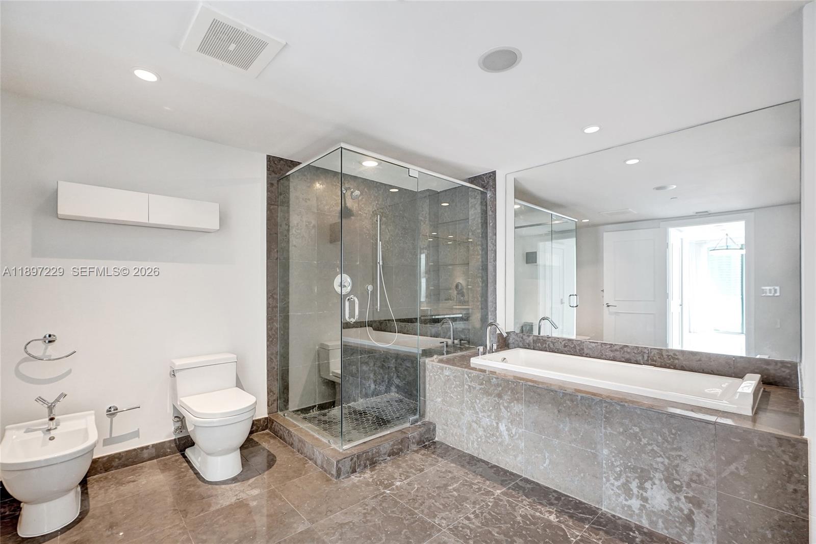 495 Brickell Avenue, Unit 2301 Miami, FL 33131 - Photo 25 of 61 a large spacious bathroom with a double vanity sink a mirror and a toilet