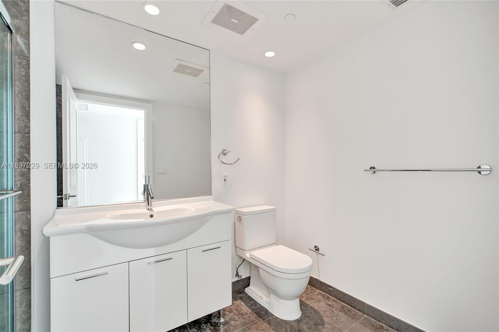 495 Brickell Avenue, Unit 2301 Miami, FL 33131 - Photo 26 of 61 a bathroom with a toilet a sink a mirror and vanity