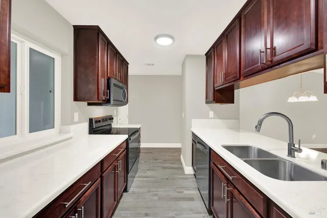 a kitchen with stainless steel appliances a sink stove and cabinets
