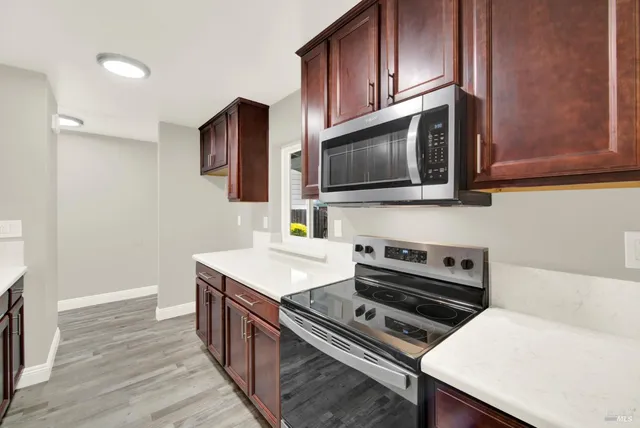 a kitchen with granite countertop stainless steel appliances wooden cabinets sink and stove