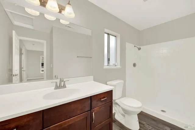 a bathroom with a toilet a sink a tub and mirror