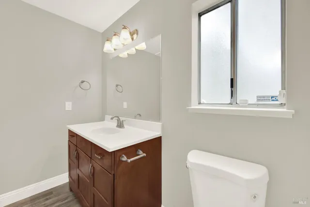 a bathroom with a sink a toilet and a mirror