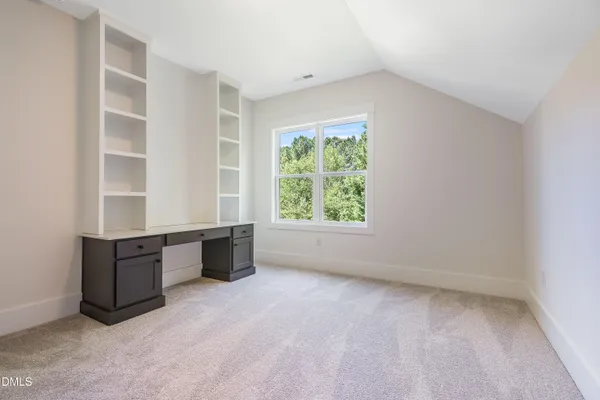 a view of an empty room with wooden floor fireplace and a window