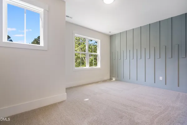 an empty room with a window and a ceiling fan