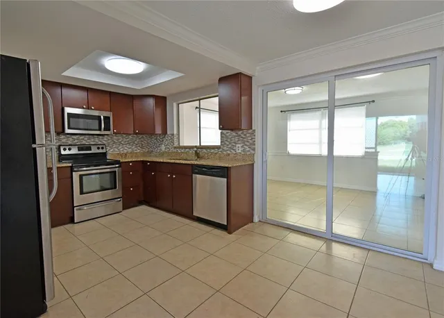 a kitchen with stainless steel appliances granite countertop a stove sink and cabinets