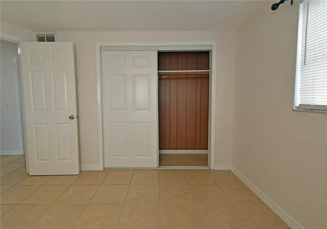 an empty room with windows and closet