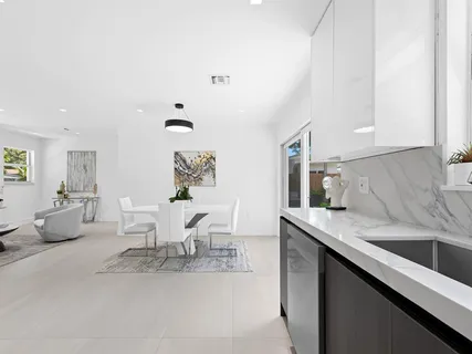 a kitchen with a table chairs and white cabinets