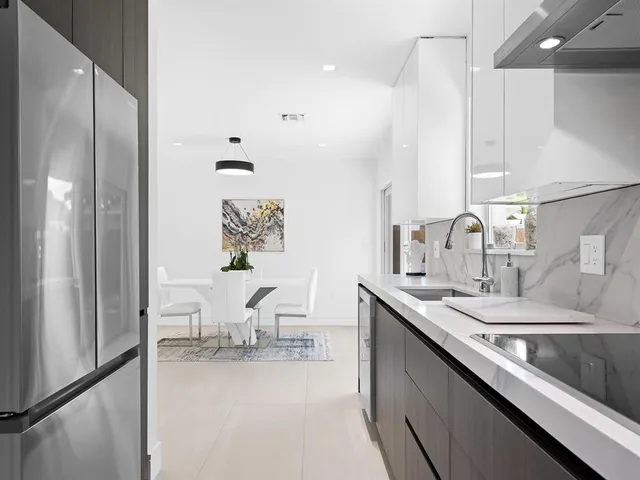 a kitchen with a sink cabinets and chairs