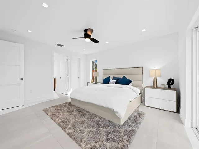 a bedroom with a large bed and a chandelier