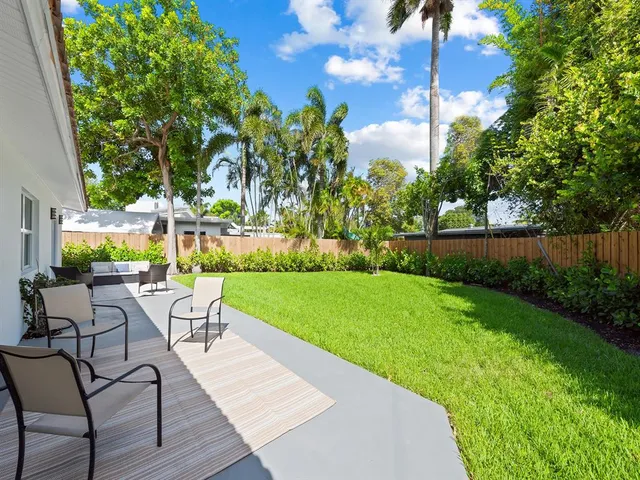 a view of a chairs and table in patio with wooden fence