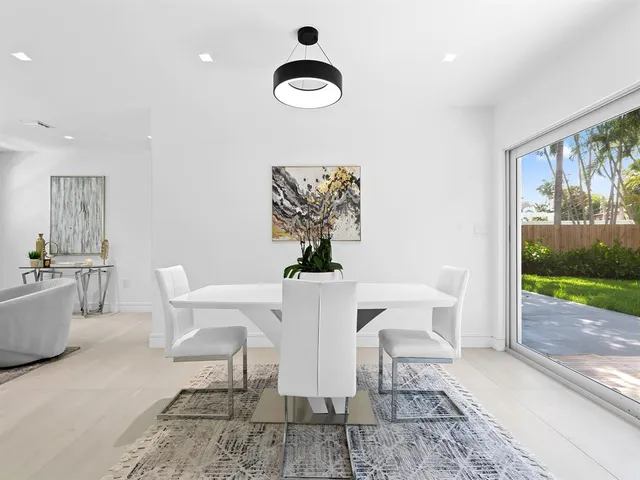 a view of a dining room with furniture wooden floor and a floor to ceiling window