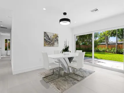 a dining room with furniture and a floor to ceiling window
