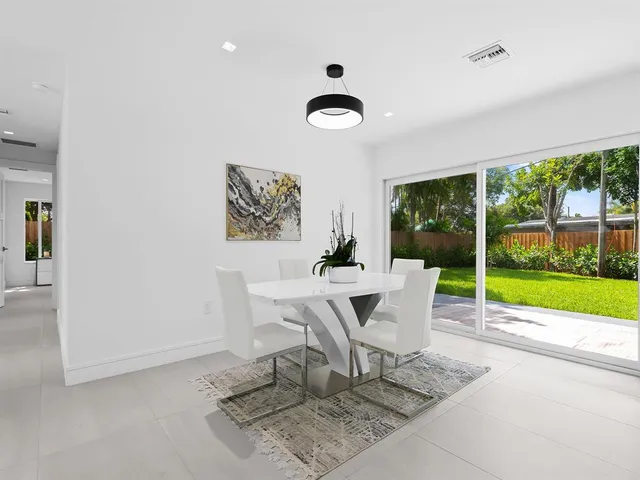 a dining room with furniture and a floor to ceiling window