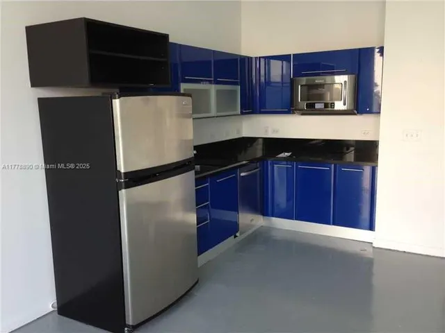 a kitchen with a refrigerator and a microwave