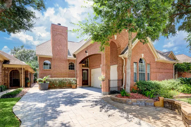 a front view of a house with a yard and potted plants