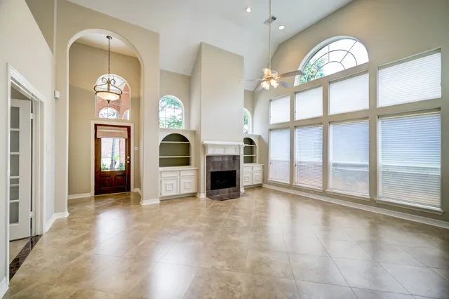 an empty room with a fireplace and windows