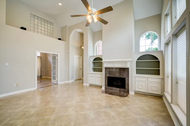 an empty room with fireplace and fan
