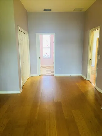 a view of empty room with wooden floor