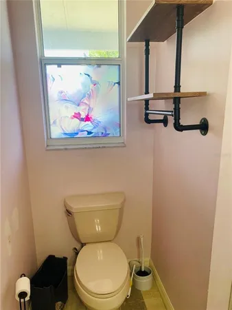 a bathroom with a toilet and a picture on the wall