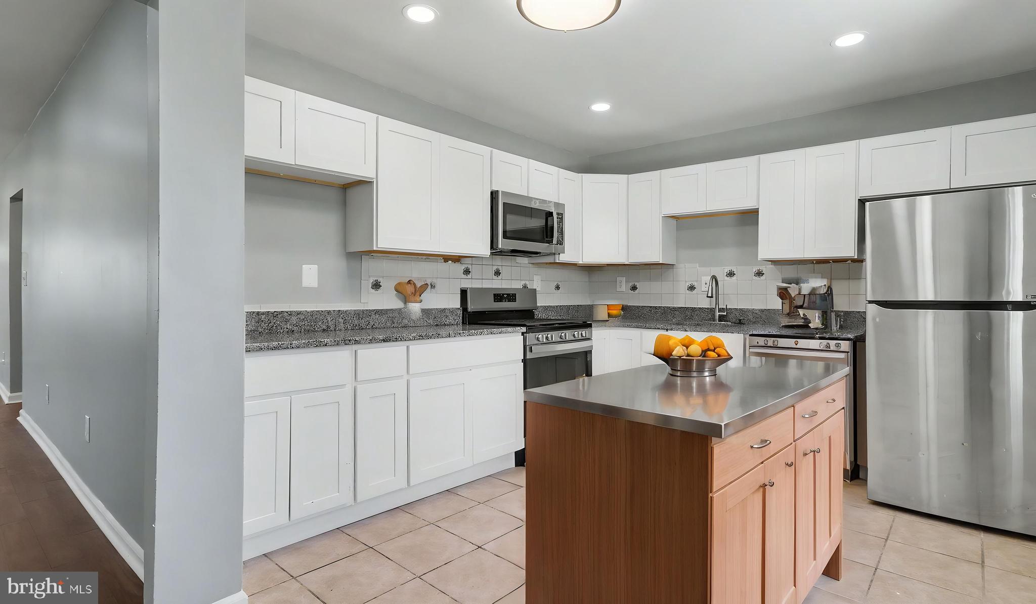 4203 Shell Street Capitol Heights, MD 20743 - Photo 39 of 47 a kitchen with refrigerator a sink a stove a microwave and cabinets