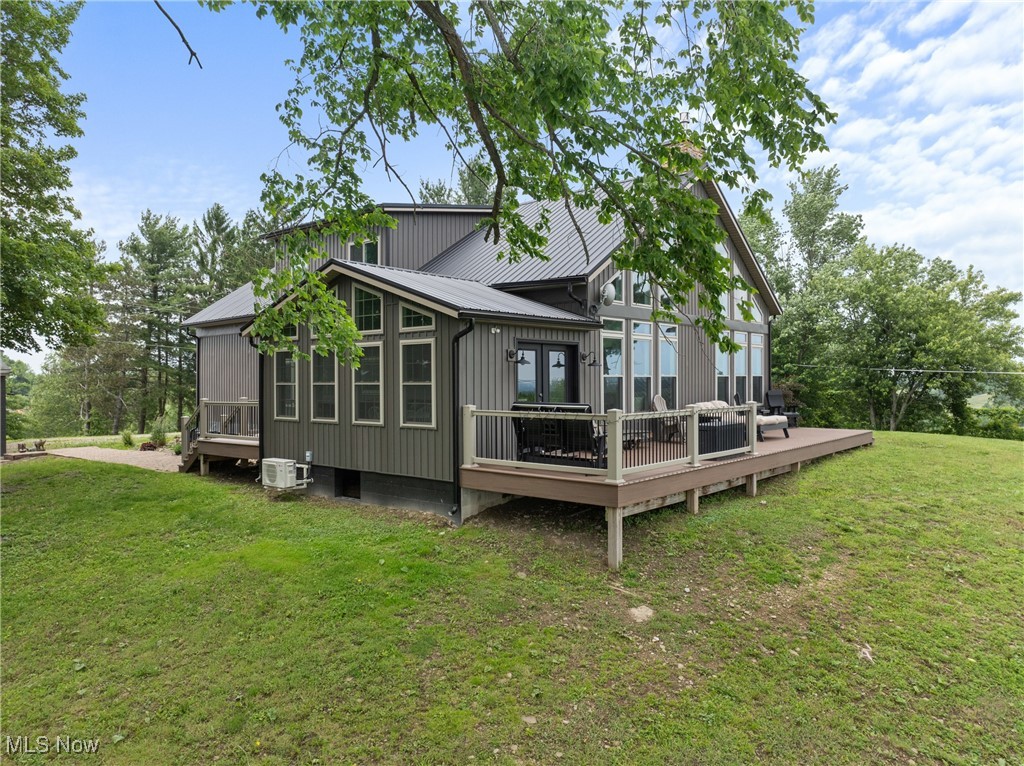 56380 Hospital Road Bellaire, OH 43906 - Photo 33 of 45 Rear view of house featuring a wooden deck, metal roof, a yard, a sunroom, and ac unit