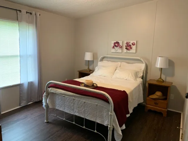 a bedroom with a bed and a lamp next to a window