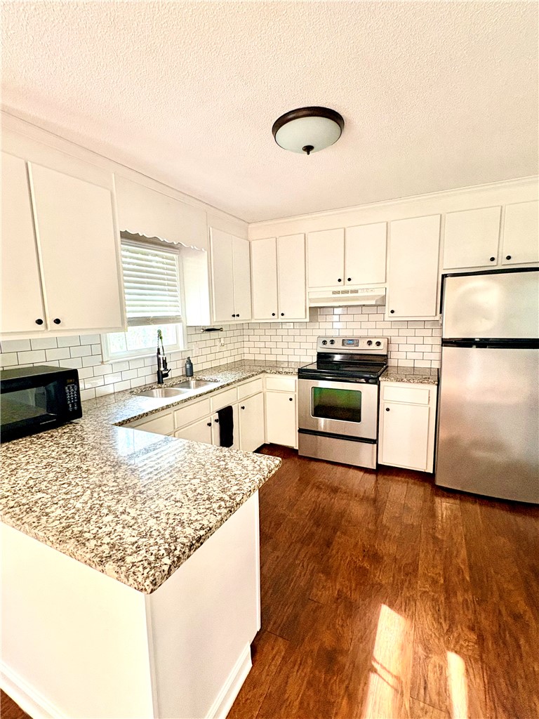516 Carole Avenue Anderson, SC 29625 - Photo 9 of 34 This bright kitchen features wood flooring and a classic subway tile backsplash.