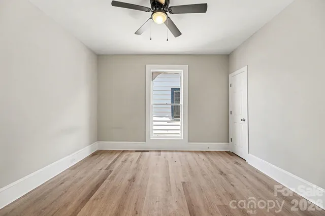 an empty room with wooden floor and entrance