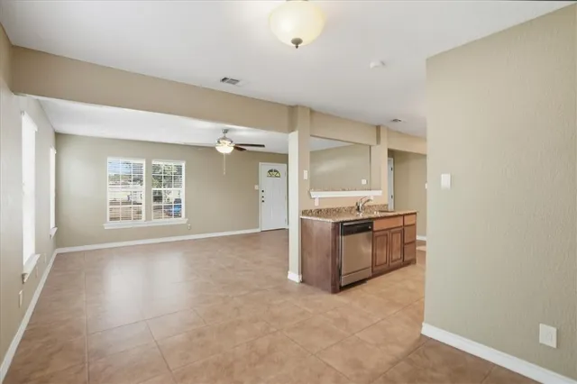 a kitchen with granite countertop a stove a sink and a refrigerator