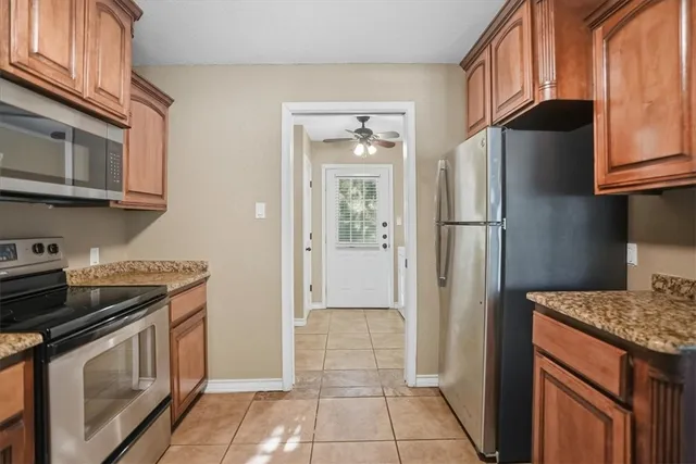 a kitchen with stainless steel appliances granite countertop a refrigerator a stove and a sink