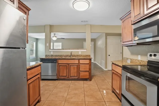 a kitchen with stainless steel appliances granite countertop a sink and a stove