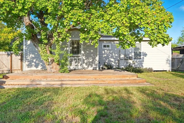 a view of a house with a yard and basketball court