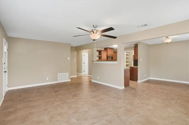 an empty room with a empty space and a ceiling fan