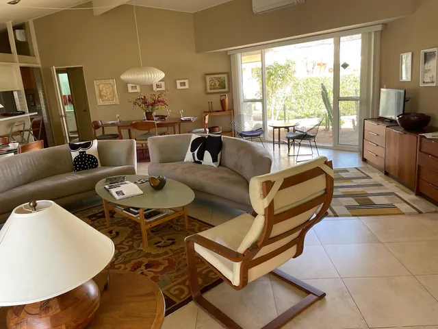 a living room with patio furniture and a large window