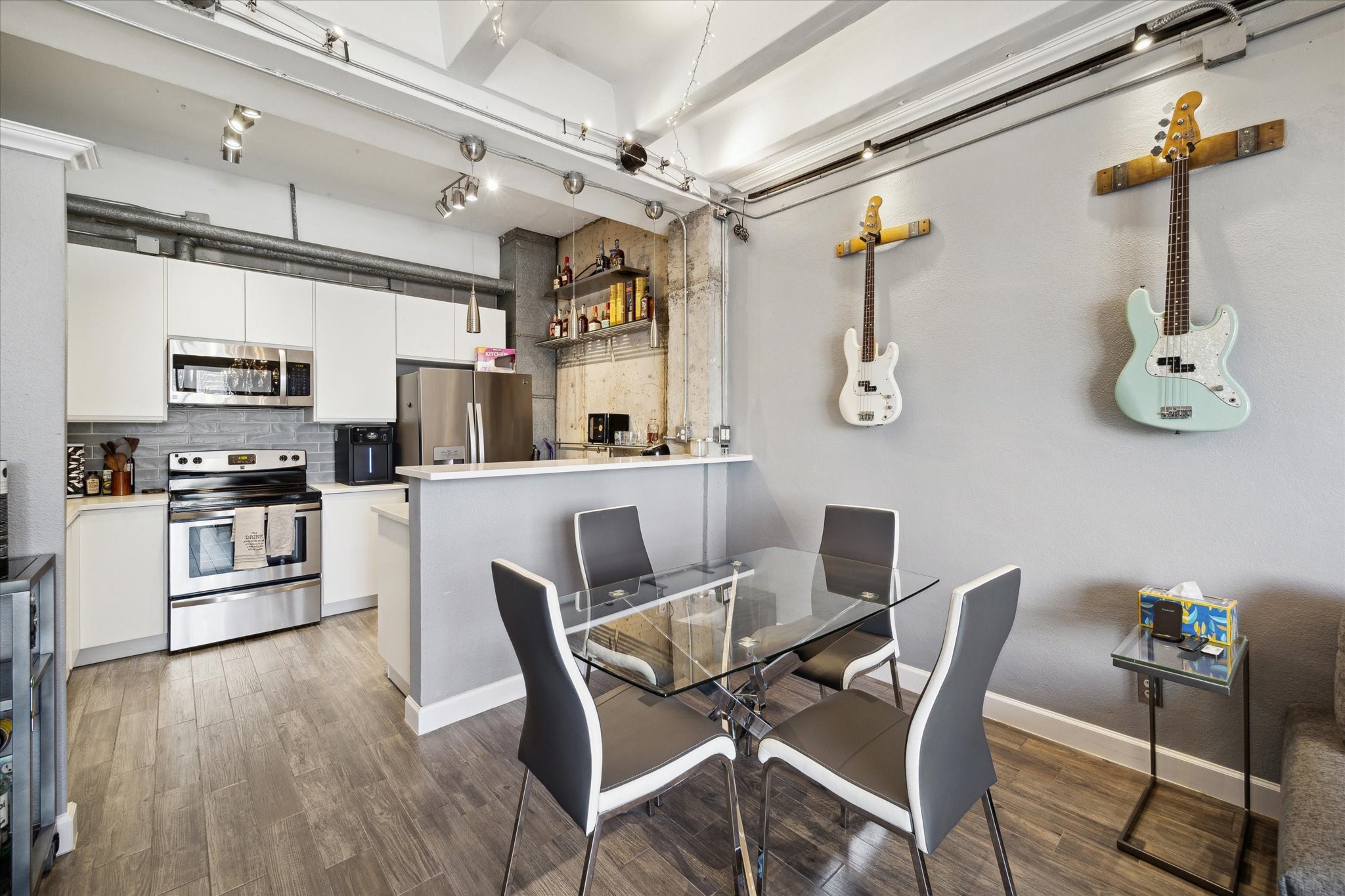 2016 Main Street, Unit 2417 Houston, TX 77002 - Photo 1 of 40 a kitchen with stainless steel appliances kitchen island granite countertop a dining table chairs and white cabinets