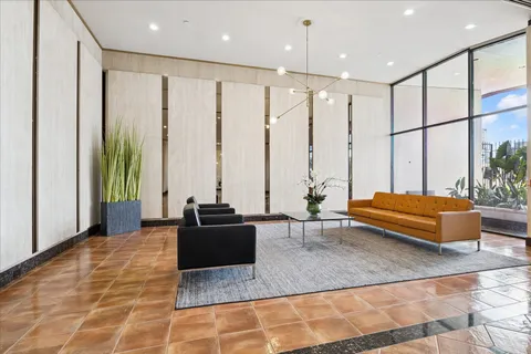 a spacious bedroom with a large window and a rug