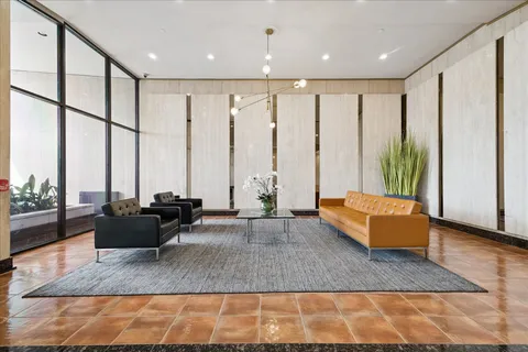 a living room with furniture and large windows