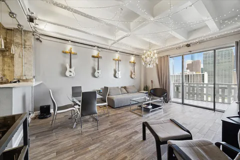 a living room with couches a dining table and chairs with wooden floor