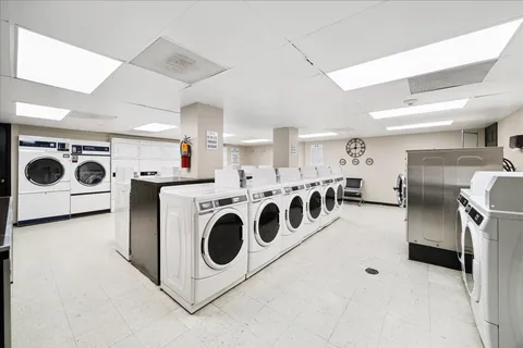 a utility room with stainless steel appliances wooden cabinets and stove top oven