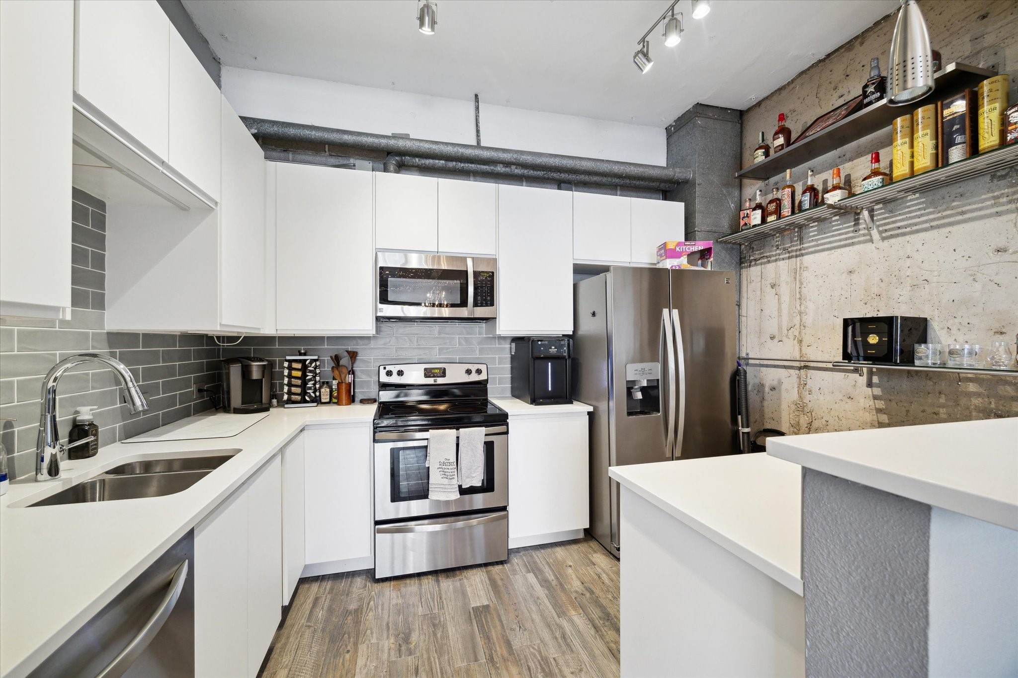 2016 Main Street, Unit 2417 Houston, TX 77002 - Photo 7 of 40 a kitchen with a sink a stove a microwave and refrigerator